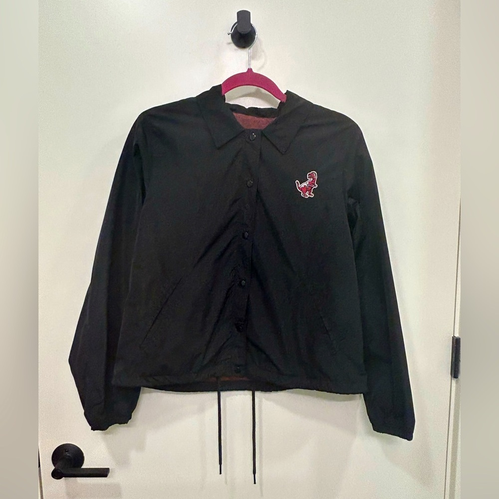 BDG black polyester button up jacket with Dino patch, size M.